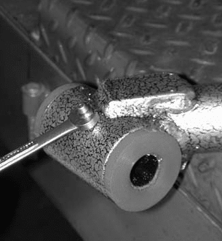 Installing grease fitting into pivot tube with nut driver