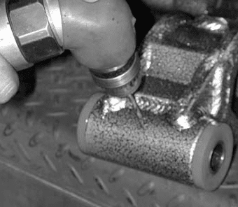 Drilling the 1/8 inch hole through the zerk fitting hole into bushing and outer sleeve