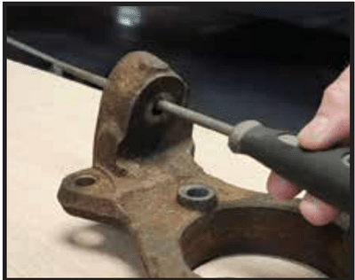 Die grinder removing a burr from the upper ball joint taper on a 2016–2018 steel knuckle