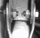 DJM lower shock extender bolted over the factory shock mount with the shock attached to the rounded end