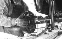 Sliding the rear axle toward the passenger side to clear the leaf spring over the brake drum