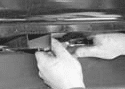 Unbolting the brake cable bracket from the driver side frame rail